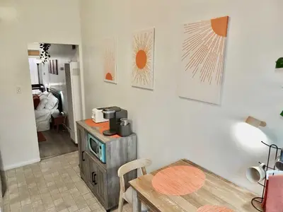 a living room with a table and a microwave at Sand Sun & Second - Charming Studio within Walking Distance to Beach in Long Beach