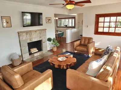 a living room with leather furniture and a fireplace at The Belmont Beach Bungalow - Pool & Hot tub in Long Beach