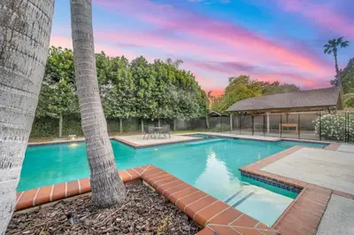 a swimming pool with two palm trees and a gazebo at The Otsego Hideaway in Los Angeles