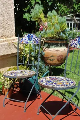two chairs and a table in front of some plants at Sweet Dreams B&B LA in Sherman Oaks