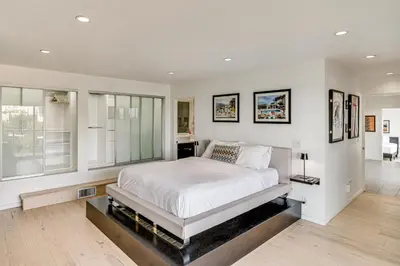 a bedroom with a large white bed and windows at Walk to Sunset Strip Modern Home in WeHo Hills! in Los Angeles
