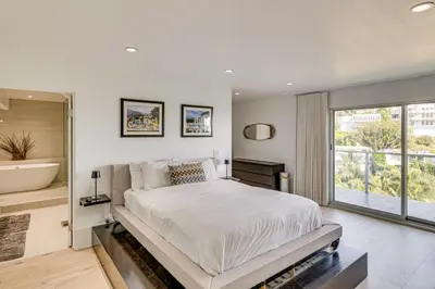 a white bedroom with a large bed and a tub at Walk to Sunset Strip Modern Home in WeHo Hills! in Los Angeles