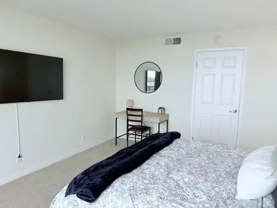 a bedroom with a bed and a desk and a television at Luxury Meets Sea of Dreams in Los Angeles