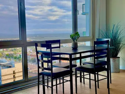 a dining room table and chairs with a view of the ocean at Luxury Meets Sea of Dreams in Los Angeles