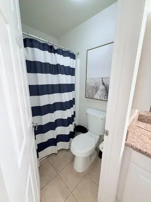 a bathroom with a toilet and a blue and white shower curtain at Luxury Meets Sea of Dreams in Los Angeles