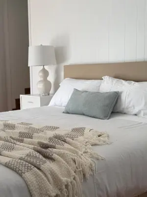a white bed with a blanket and a pillow on it at Steps to Sand Cozy 3BR Partial Ocean Views in Manhattan Beach