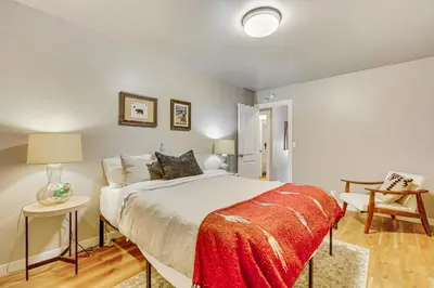 a bedroom with a bed with a red blanket on it at 2 Mi to Lake Arrowhead Treetop Retreat with Deck in Lake Arrowhead