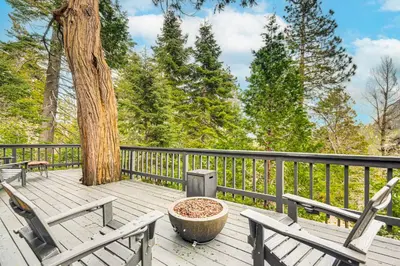 a wooden deck with two chairs and a tree at 2 Mi to Lake Arrowhead Treetop Retreat with Deck in Lake Arrowhead