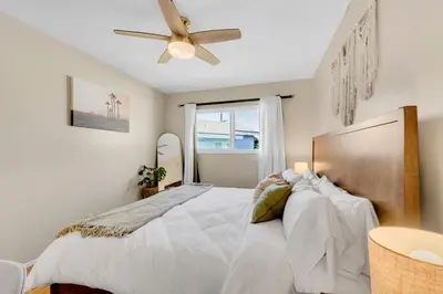 a bedroom with a white bed with a ceiling fan at Beautifully Remodeled 2bed1bath Apartment Top Location 15 min to Beach in Los Angeles