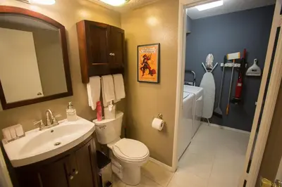 a bathroom with a sink and a toilet and a mirror at Radiator Springs by Funtierland Vacation Rentals in Anaheim