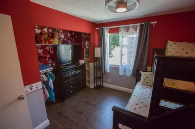 a room with a bedroom with red walls and a television at Radiator Springs by Funtierland Vacation Rentals in Anaheim