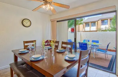 a dining room with a table with chairs and a clock at Tron by Funtierland Vacation Rentals in Anaheim