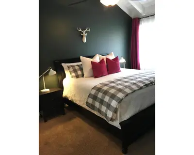 a bedroom with a bed with red and white pillows at Arendelle by Funtierland Vacation Rentals in Anaheim