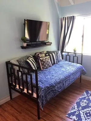 a bedroom with a bed with a tv on the wall at Pixie Hollow by Funtierland Vacation Rentals in Anaheim