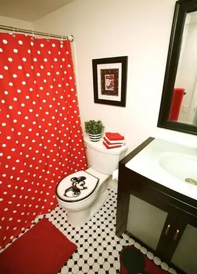 a bathroom with a red shower curtain and a toilet at Pixie Hollow by Funtierland Vacation Rentals in Anaheim
