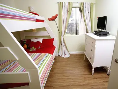 a small bedroom with a bunk bed and a dresser at Pixie Hollow by Funtierland Vacation Rentals in Anaheim