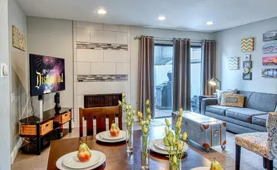 a living room with a table and a couch at Maleficents Retreat by Funtierland Vacation Rentals in Anaheim