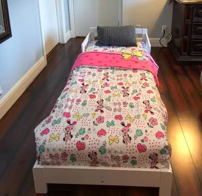 a bedroom with a bed with a pink bedspread with apples at Maleficents Retreat by Funtierland Vacation Rentals in Anaheim