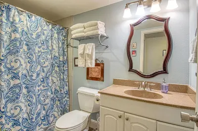 a bathroom with a toilet and a sink and a mirror at Maleficents Retreat by Funtierland Vacation Rentals in Anaheim