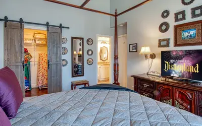 a bedroom with a bed and a tv on a wall at Maleficents Retreat by Funtierland Vacation Rentals in Anaheim