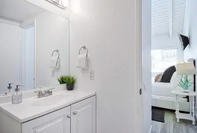 a white bathroom with a sink and a mirror at New Suite Escapes 6 by Funtierland Vacation Rentals in Anaheim