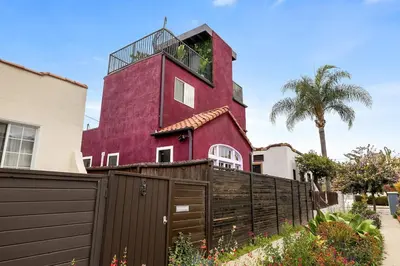 a red house with a fence in front of it at Hollywood Glam Hideaway - Steps to Walk of Fame in Los Angeles