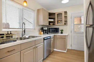 a kitchen with a sink and a refrigerator at Hollywood Glam Hideaway - Steps to Walk of Fame in Los Angeles