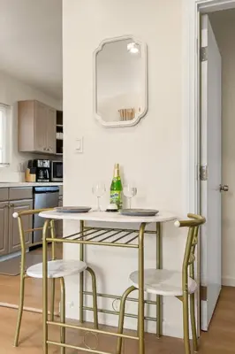 a dining room with a table and chairs and a mirror at Hollywood Glam Hideaway - Steps to Walk of Fame in Los Angeles