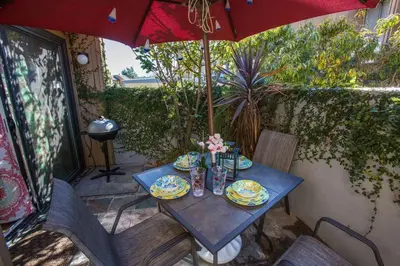 a table with plates of food and an umbrella at Bedknobs and Broomsticks by Funtierland Vacation Rentals in Anaheim