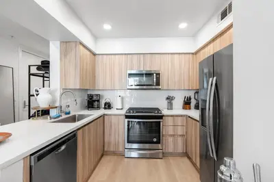 a kitchen with wooden cabinets and a stainless steel refrigerator at Huge Stylish Apartment Santa Mon in Los Angeles