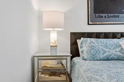 a bedside table with a lamp next to a bed at Huge Stylish Apartment Santa Mon in Los Angeles