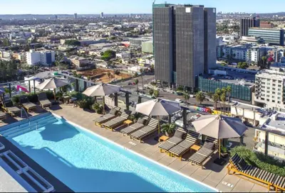 an overhead view of a pool with chairs and umbrellas at Rooftop Pool Modern 2BR, 2BA - Panoramic Hollywood views in Los Angeles