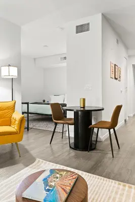 a living room with a table and chairs at Spacious and Bright West Hollywood Pool & Gym in Los Angeles