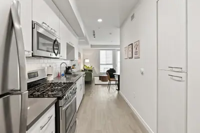 a kitchen with white cabinets and a stove top oven at Spacious and Bright West Hollywood Pool & Gym in Los Angeles