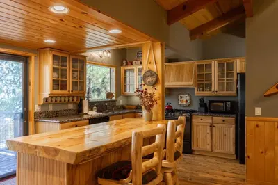 a kitchen with wooden cabinets and a large wooden table at Ultimate Lakeview Lodge and ON THE LAKE! with a Hot-Tub! in Big Bear Lake