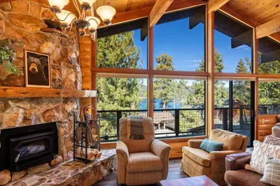 a large living room with a large stone fireplace at Ultimate Lakeview Lodge and ON THE LAKE! with a Hot-Tub! in Big Bear Lake