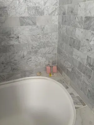 a white toilet in a bathroom with gray tiles at Charming Studio Four with Private Patio in Los Angeles