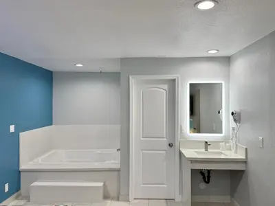 a bathroom with a tub and a sink and a white door at Royale Inn \u8001\u723a\u5ba2\u68e7 - San Gabriel, Los Angeles in Rosemead