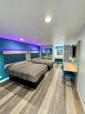 two beds in a room with a desk and a desk at Royale Inn \u8001\u723a\u5ba2\u68e7 - San Gabriel, Los Angeles in Rosemead