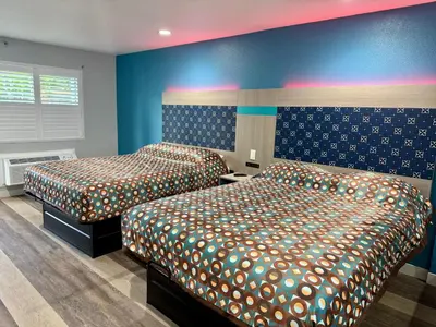 two beds in a room with blue walls at Royale Inn \u8001\u723a\u5ba2\u68e7 - San Gabriel, Los Angeles in Rosemead