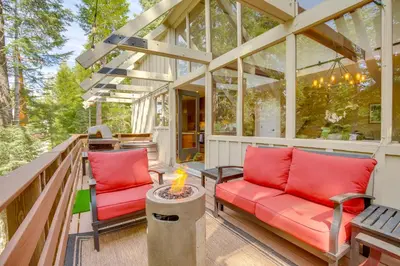 a screened in porch with two red chairs and a table at Walk to Lake Arrowhead Village Gem with Lake Access in Lake Arrowhead