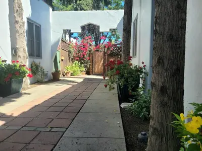 a walkway with flowers on the side of a house at Cozy Apartment Two in Hollywood! in Los Angeles