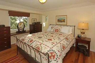 a bedroom with a bed and a dresser and a window at Bella Vista by Paradise Retreats in Carpinteria