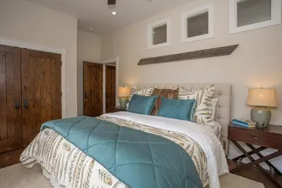 a bedroom with a large bed with blue pillows at Bella Vista by Paradise Retreats in Carpinteria