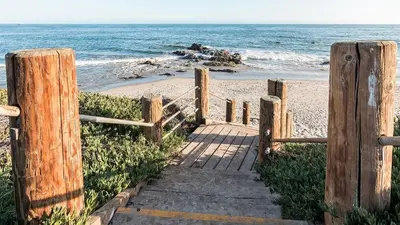 a wooden staircase leading to a beach with the ocean at Bella Vista by Paradise Retreats in Carpinteria