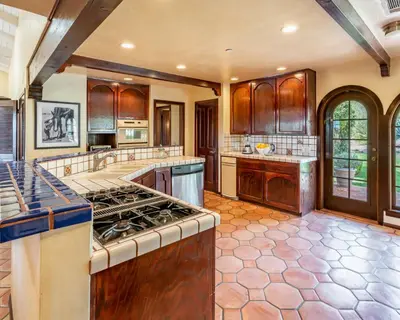 a large kitchen with wooden cabinets and a stove top oven at Casa Tranquility by Paradise Retreats in Carpinteria