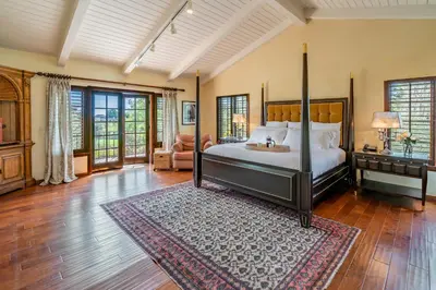 a bedroom with a canopy bed and a rug at Casa Tranquility by Paradise Retreats in Carpinteria