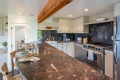 a kitchen with a granite counter top and appliances at Ocean Breeze Abode and Bungalow by Paradise Retreats in Summerland