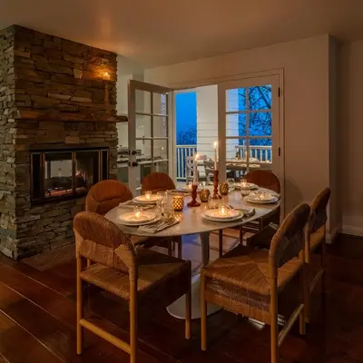 a dining room with a table and chairs and a fireplace at Ocean Breeze Abode and Bungalow by Paradise Retreats in Summerland