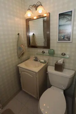 a bathroom with a toilet and a sink and a mirror at Rincon Retreat by Paradise Retreats in Carpinteria